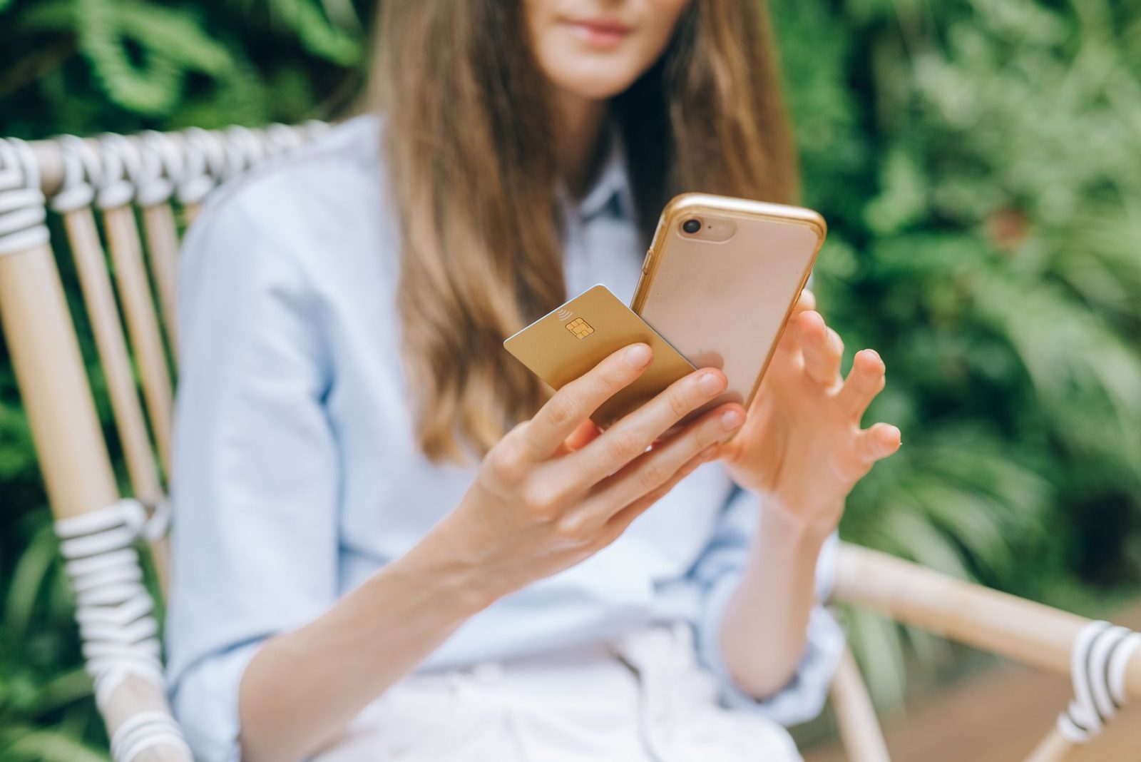 Woman holding her phone and a bank card